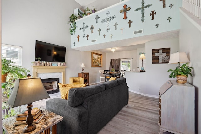 2104 Loudenslager Dr, Thompsons Station, TN 37179 - living room featuring a high ceiling, healthy amount of natural light, wood finished floors, and a fireplace