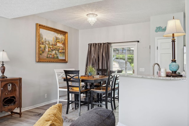 2104 Loudenslager Dr, Thompsons Station, TN 37179 - dining area with light wood finished floors, a textured ceiling, and a chandelier