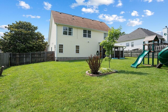 2104 Loudenslager Dr, Thompsons Station, TN 37179 - back of property with a fenced backyard, a playground, and a sunroom
