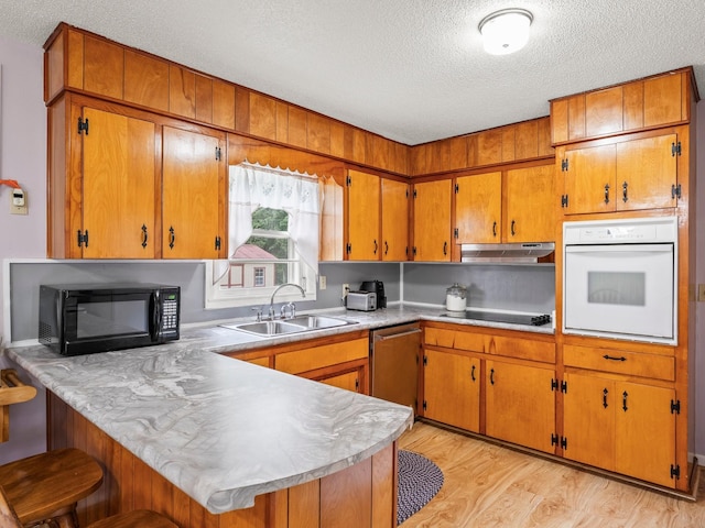 1574 Midway Rd, Sewanee, TN 37375 - kitchen featuring black appliances, a textured ceiling, a sink, a peninsula, and brown cabinets