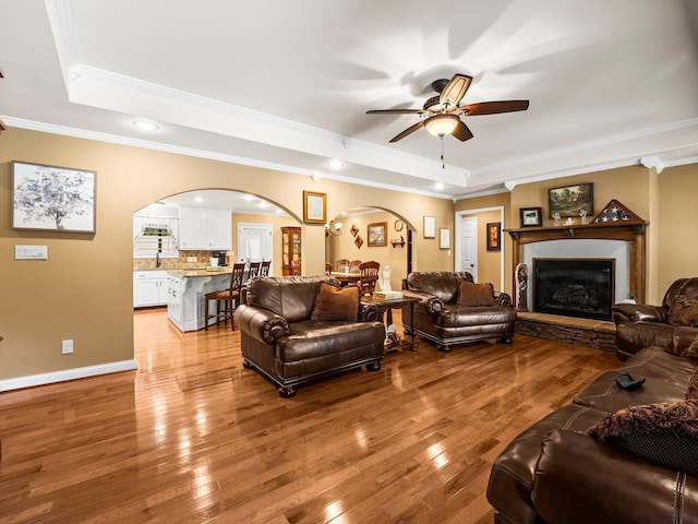 1574 Midway Rd, Sewanee, TN 37375 - living area featuring a raised ceiling, arched walkways, crown molding, ceiling fan, and light wood finished floors