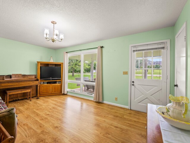 1574 Midway Rd, Sewanee, TN 37375 - living room featuring a chandelier, plenty of natural light, light wood-style flooring, and a textured ceiling