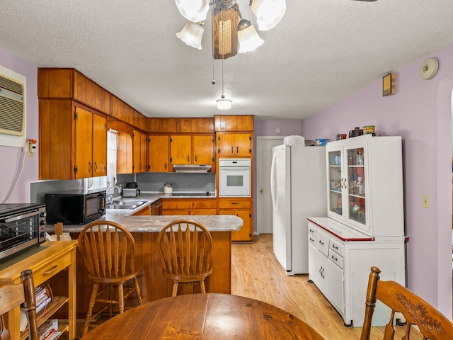 1574 Midway Rd, Sewanee, TN 37375 - kitchen featuring white appliances, a peninsula, a sink, under cabinet range hood, and a textured ceiling