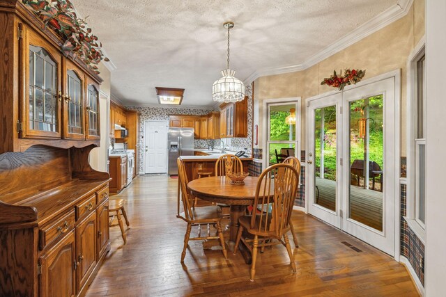 6873 Giles Hill Rd, College Grove, TN 37046 - dining area featuring a textured ceiling, dark wood-type flooring, crown molding, french doors, and a chandelier