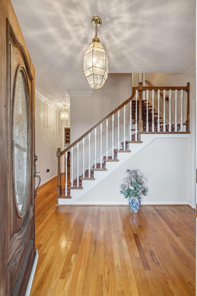 6873 Giles Hill Rd, College Grove, TN 37046 - entryway with a textured ceiling, stairs, wood finished floors, baseboards, and a chandelier