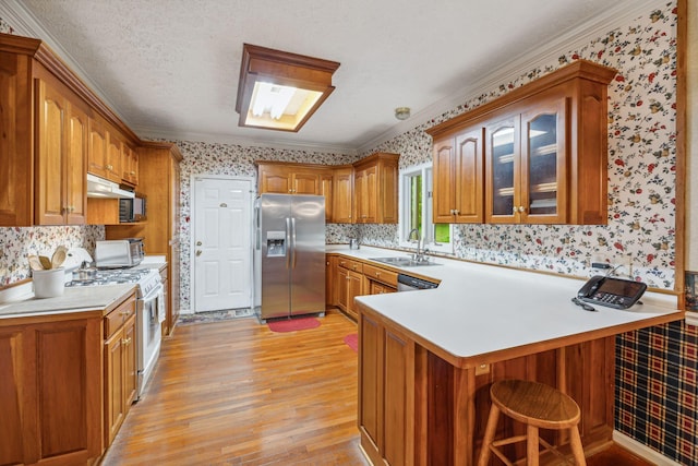 6873 Giles Hill Rd, College Grove, TN 37046 - kitchen with appliances with stainless steel finishes, wallpapered walls, a peninsula, light wood finished floors, and brown cabinetry
