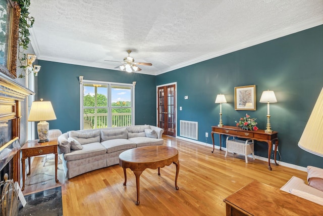 6873 Giles Hill Rd, College Grove, TN 37046 - living area featuring a textured ceiling, wood finished floors, a ceiling fan, a fireplace, and ornamental molding
