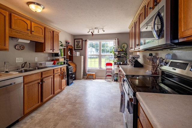 674 Superior Ln, Clarksville, TN 37043 - kitchen featuring appliances with stainless steel finishes, brown cabinets, light countertops, and a textured ceiling
