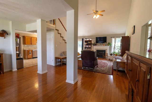 674 Superior Ln, Clarksville, TN 37043 - living area with hardwood / wood-style flooring, a glass covered fireplace, a ceiling fan, stairs, and high vaulted ceiling