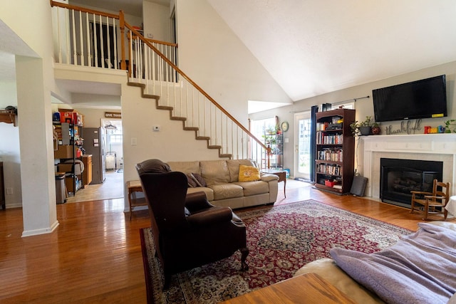 674 Superior Ln, Clarksville, TN 37043 - living room featuring high vaulted ceiling, wood finished floors, a tile fireplace, and stairs