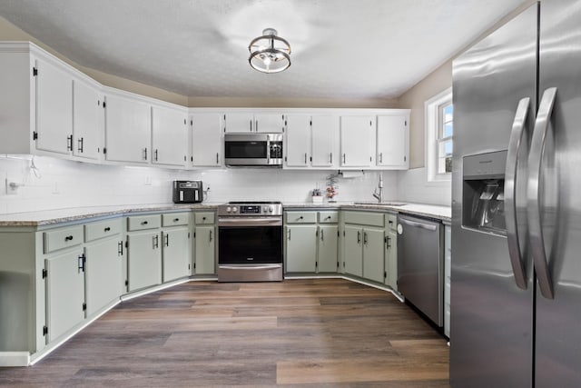 2237 Cold Springs Rd, Lafayette, TN 37083 - kitchen featuring appliances with stainless steel finishes, backsplash, dark wood-style flooring, light countertops, and a sink