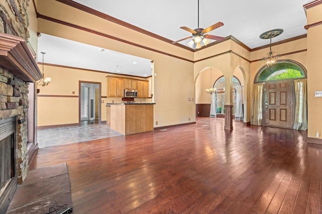 3696 Prestwicke Pl, Adams, TN 37010 - unfurnished living room with a chandelier, arched walkways, ornamental molding, a stone fireplace, and hardwood / wood-style flooring