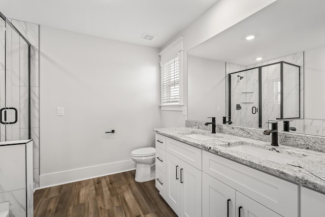 556 Kingwood Ln, White House, TN 37188 - bathroom featuring double vanity, toilet, baseboards, wood finished floors, and a shower stall