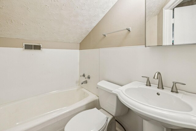8663 Dog Creek Rd, Primm Springs, TN 38476 - bathroom featuring a textured ceiling, toilet, a tub, a sink, and lofted ceiling