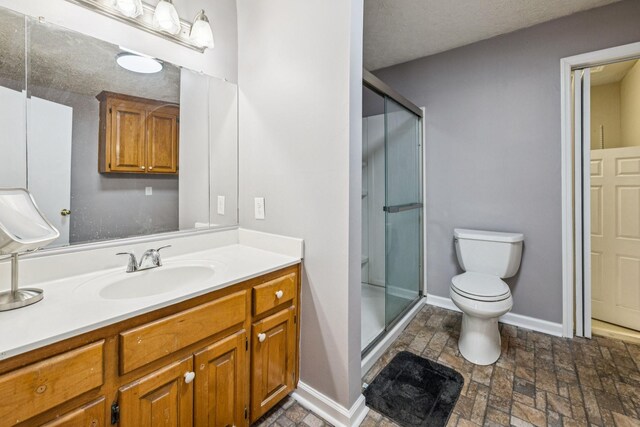 8663 Dog Creek Rd, Primm Springs, TN 38476 - full bathroom featuring toilet, vanity, a stall shower, stone finish floors, and baseboards