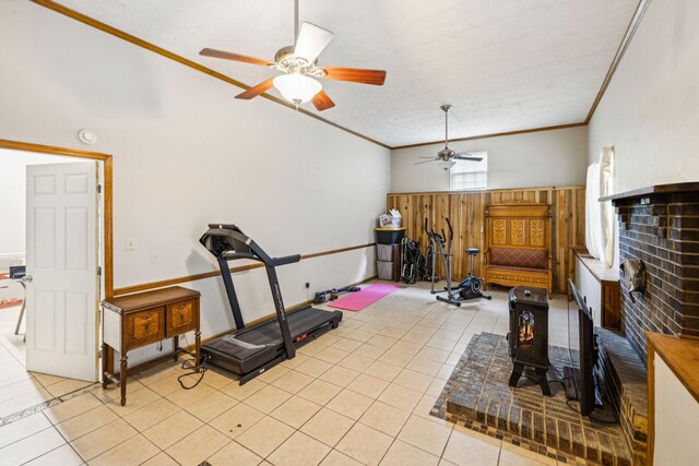 8663 Dog Creek Rd, Primm Springs, TN 38476 - exercise area with ceiling fan, light tile patterned flooring, crown molding, a wood stove, and wood walls