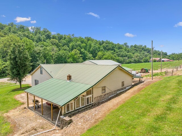 8663 Dog Creek Rd, Primm Springs, TN 38476 - view of side of property featuring driveway, a carport, metal roof, and a lawn