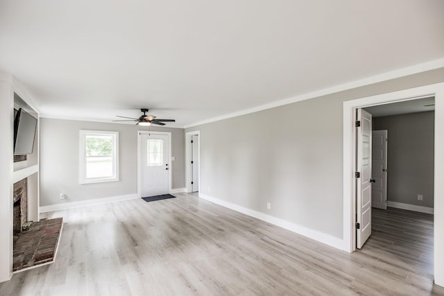 1108 Pruitt Ln, Gallatin, TN 37066 - unfurnished living room featuring a ceiling fan, light wood-style floors, a brick fireplace, and crown molding
