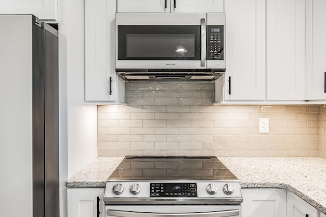 1108 Pruitt Ln, Gallatin, TN 37066 - kitchen featuring stainless steel appliances, tasteful backsplash, white cabinetry, and light stone counters