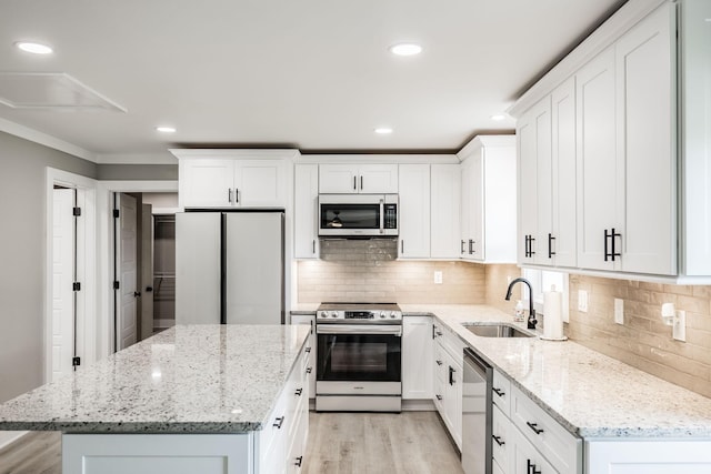 1108 Pruitt Ln, Gallatin, TN 37066 - kitchen with appliances with stainless steel finishes, a center island, light wood-style floors, white cabinets, and recessed lighting