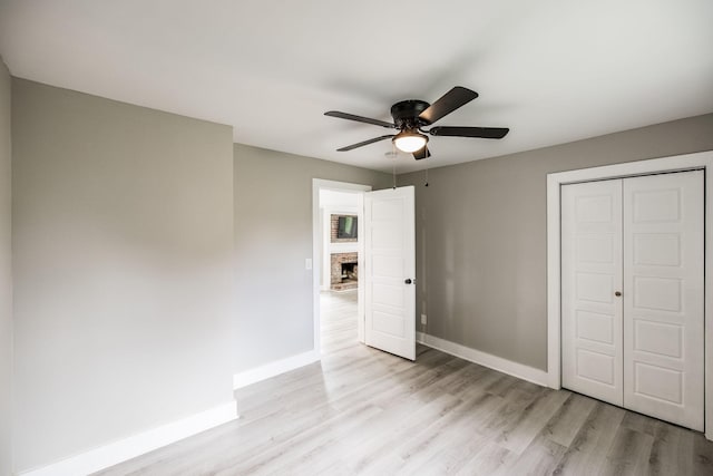 1108 Pruitt Ln, Gallatin, TN 37066 - unfurnished bedroom featuring light wood-type flooring, a closet, a brick fireplace, and ceiling fan