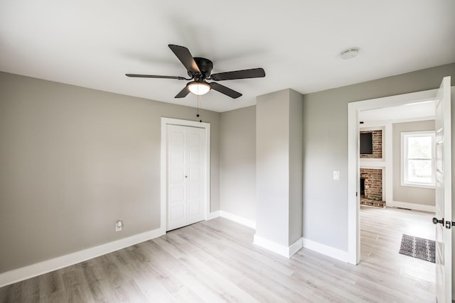 1108 Pruitt Ln, Gallatin, TN 37066 - unfurnished bedroom with light wood-type flooring, baseboards, a fireplace, a closet, and a ceiling fan