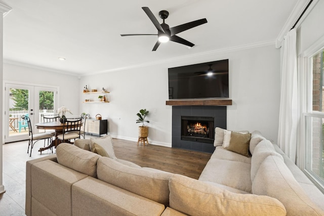 3453 Parkwood Ct, Hermitage, TN 37076 - living area featuring ornamental molding, wood finished floors, a tile fireplace, a ceiling fan, and french doors