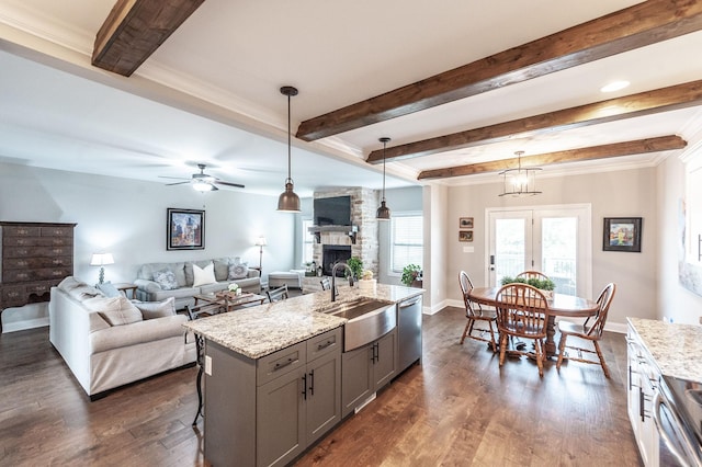 1184 Wicke Rd, Adams, TN 37010 - kitchen with a sink, gray cabinets, stainless steel dishwasher, a fireplace, and light stone countertops