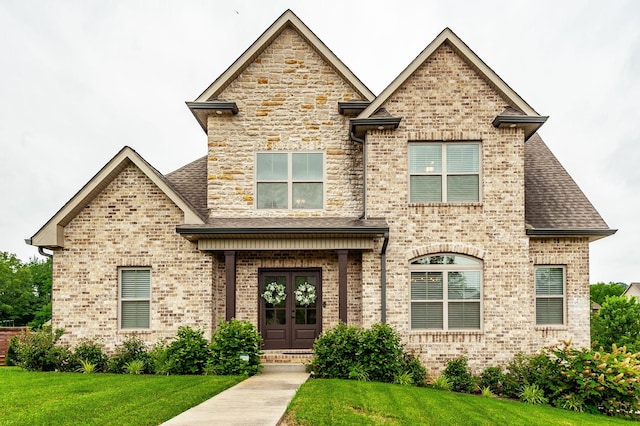 1184 Wicke Rd, Adams, TN 37010 - french country home featuring a front yard, brick siding, a shingled roof, and french doors