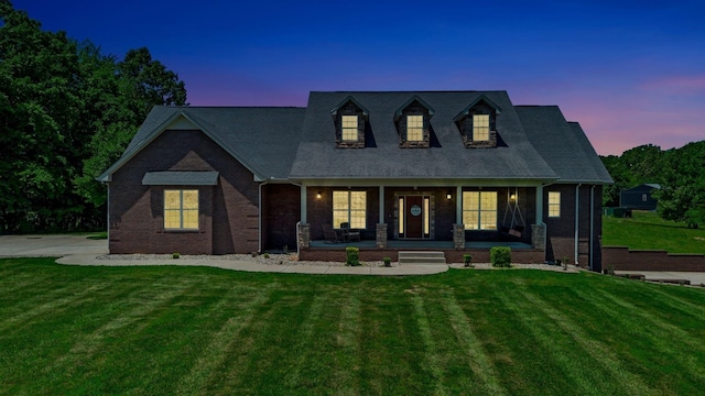 152 Camaro Dr, Chapmansboro, TN 37035 - new england style home with covered porch, a yard, and brick siding
