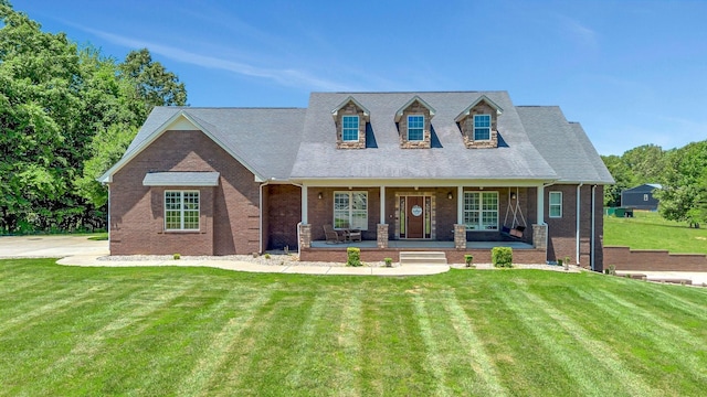 152 Camaro Dr, Chapmansboro, TN 37035 - cape cod home featuring covered porch, a front yard, and brick siding