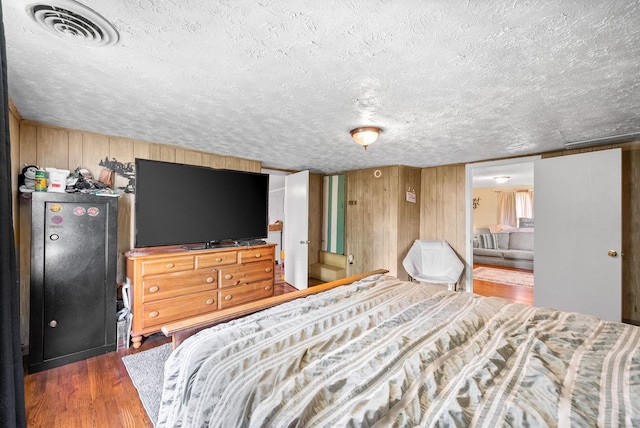 154 Crains Landing Rd, Dover, TN 37058 - bedroom with wooden walls, wood finished floors, and a textured ceiling