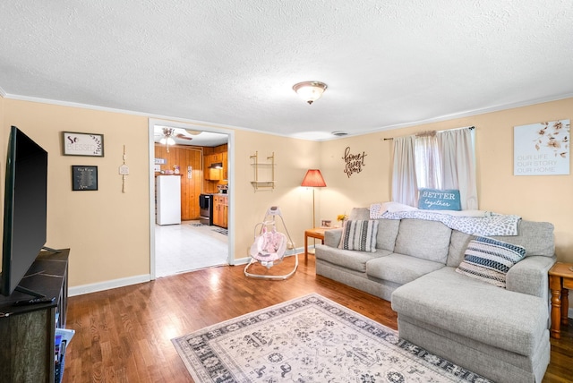 154 Crains Landing Rd, Dover, TN 37058 - living area featuring a textured ceiling, wood finished floors, ornamental molding, baseboards, and a ceiling fan