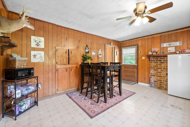 154 Crains Landing Rd, Dover, TN 37058 - dining room with light floors, a ceiling fan, wooden walls, and a textured ceiling