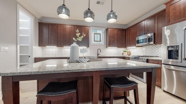 20 Daniels Dr, Franklin, TN 37064 - kitchen with stainless steel appliances, a kitchen island, decorative backsplash, a kitchen bar, and ornamental molding