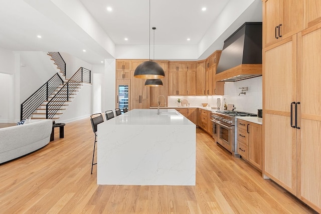 2915 Compton Rd, Nashville, TN 37215 - kitchen featuring double oven range, wall chimney exhaust hood, a sink, light brown cabinetry, and light wood-style flooring