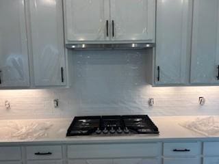 1040 Cherry Tree Dr, Mount Juliet, TN 37122 - kitchen featuring gas cooktop, light countertops, decorative backsplash, and range hood