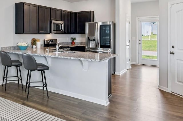 1013 Pepper Stone Dr, Lebanon, TN 37087 - kitchen with appliances with stainless steel finishes, a peninsula, dark wood finished floors, and a kitchen bar