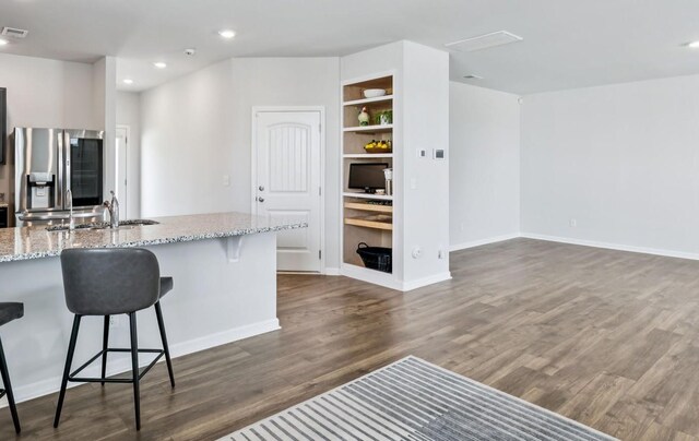 1013 Pepper Stone Dr, Lebanon, TN 37087 - kitchen featuring stainless steel fridge with ice dispenser, dark wood-type flooring, a kitchen breakfast bar, built in features, and light stone countertops