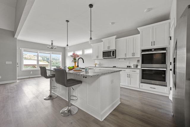 276 Indian Creek Rd, Cumberland Furnace, TN 37051 - kitchen featuring appliances with stainless steel finishes, light stone counters, dark wood finished floors, white cabinetry, and baseboards