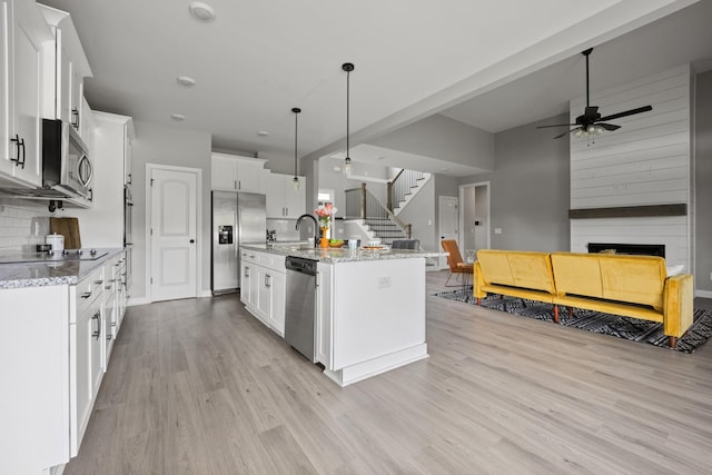 276 Indian Creek Rd, Cumberland Furnace, TN 37051 - kitchen with stainless steel appliances, light wood-style floors, open floor plan, a ceiling fan, and white cabinetry