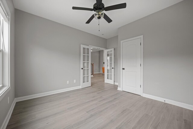 276 Indian Creek Rd, Cumberland Furnace, TN 37051 - unfurnished bedroom featuring french doors, light wood-style floors, baseboards, and ceiling fan