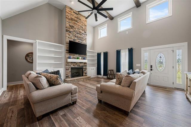 6400 Williams Rd, Cross Plains, TN 37049 - living room with high vaulted ceiling, ceiling fan, wood finished floors, a stone fireplace, and baseboards