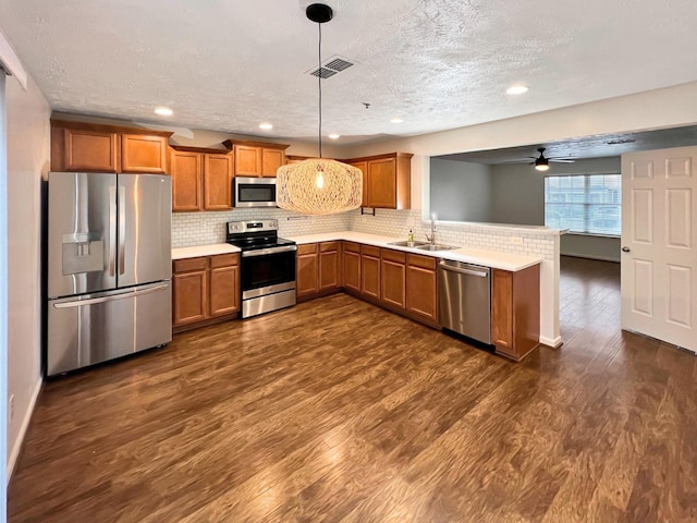 4017 Pavati Trce, Spring Hill, TN 37174 - kitchen featuring appliances with stainless steel finishes, brown cabinets, a sink, a ceiling fan, and a peninsula