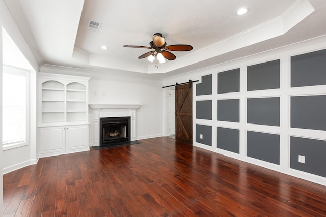 5026 Hectare Ln, La Vergne, TN 37086 - unfurnished living room featuring a raised ceiling, a barn door, ceiling fan, dark wood-style floors, and crown molding