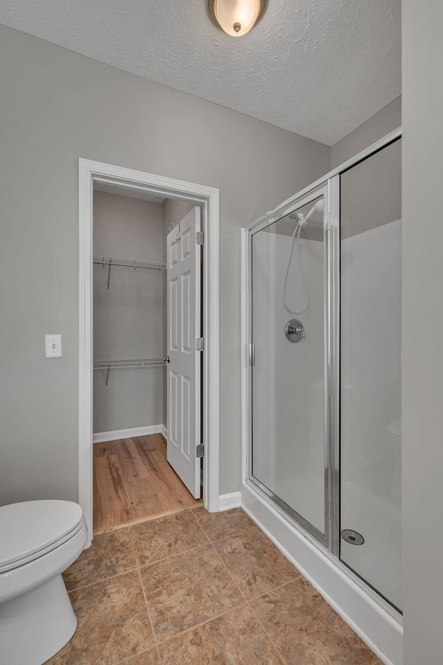 1033 Park Run Dr, Franklin, TN 37067 - full bath featuring a shower stall, a walk in closet, and a textured ceiling