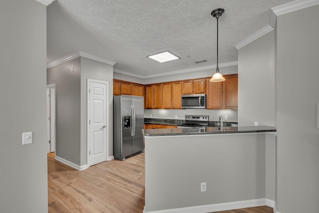 1033 Park Run Dr, Franklin, TN 37067 - kitchen with stainless steel appliances, brown cabinets, light wood-style flooring, dark stone countertops, and a peninsula