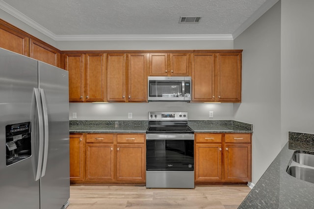 1033 Park Run Dr, Franklin, TN 37067 - kitchen with appliances with stainless steel finishes, brown cabinetry, ornamental molding, and a textured ceiling