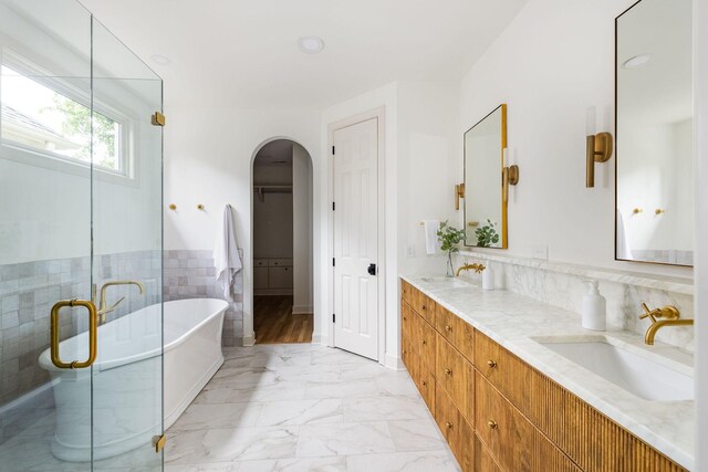 322 Starling Ln, Franklin, TN 37064 - bathroom featuring double vanity, a freestanding bath, marble look tiles, a stall shower, and a spacious closet