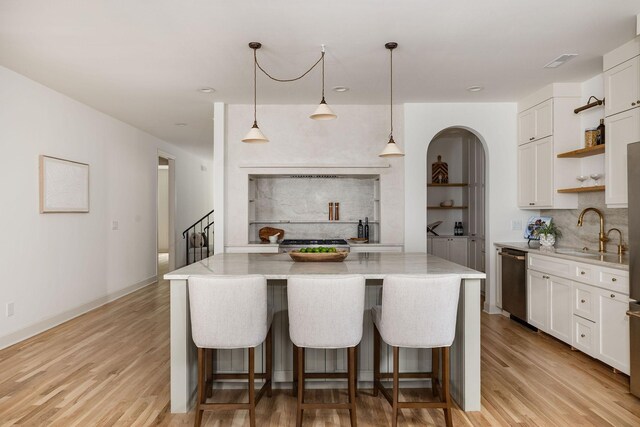 322 Starling Ln, Franklin, TN 37064 - kitchen with dishwasher, open shelves, light wood-style flooring, light stone counters, and white cabinets